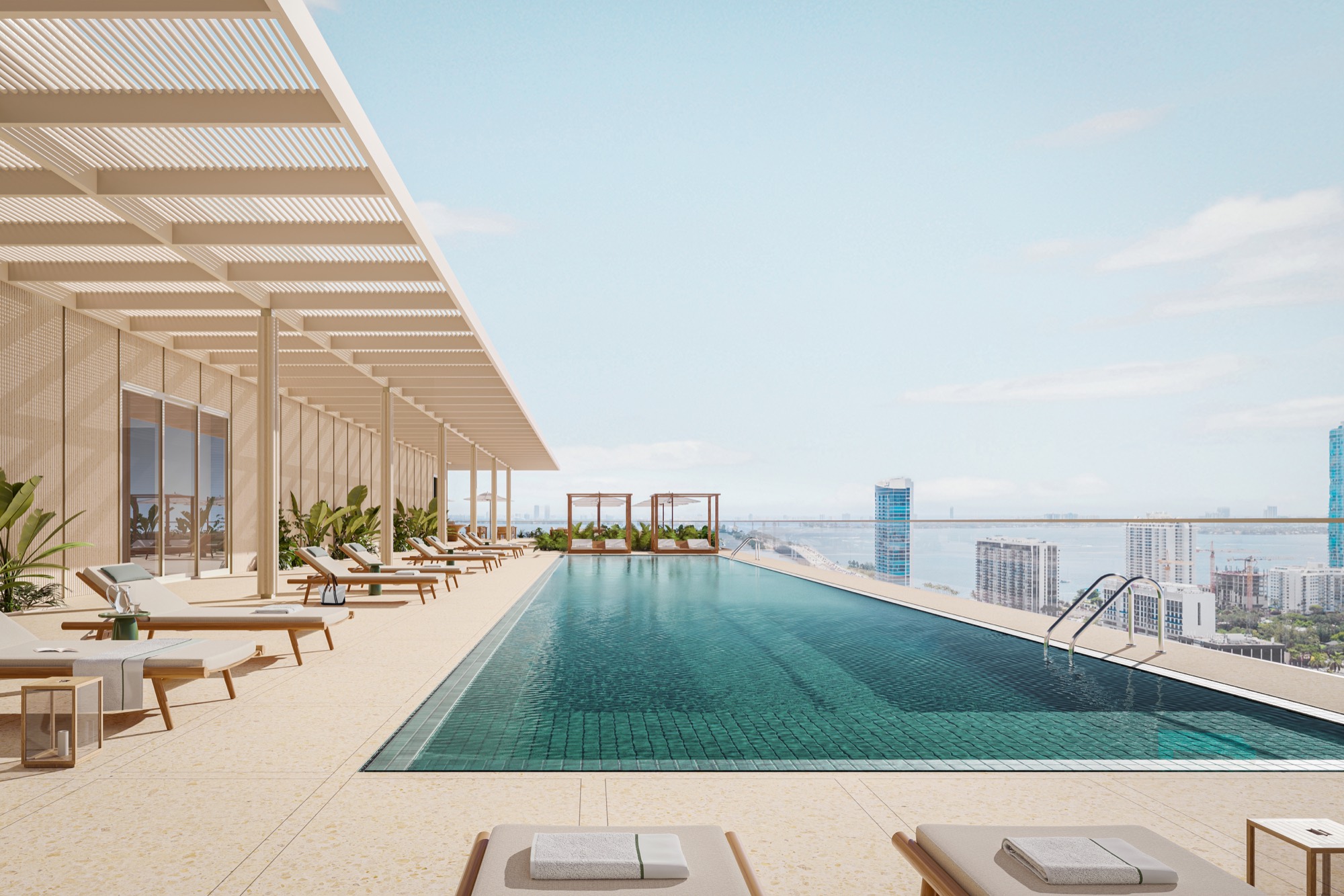 The 70-foot rooftop pool at Fouquet's Hotel & Residences — a long reflecting pool with terrazzo deck, cabanas, and lounge seating framed by the Design District skyline.